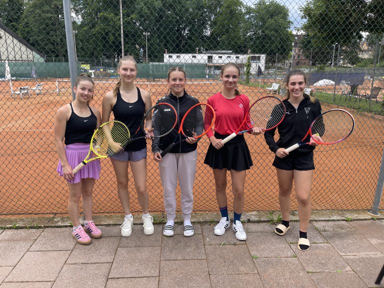 Fünfe Schülerinnen lachen in Tennisoutfits in die Kamera