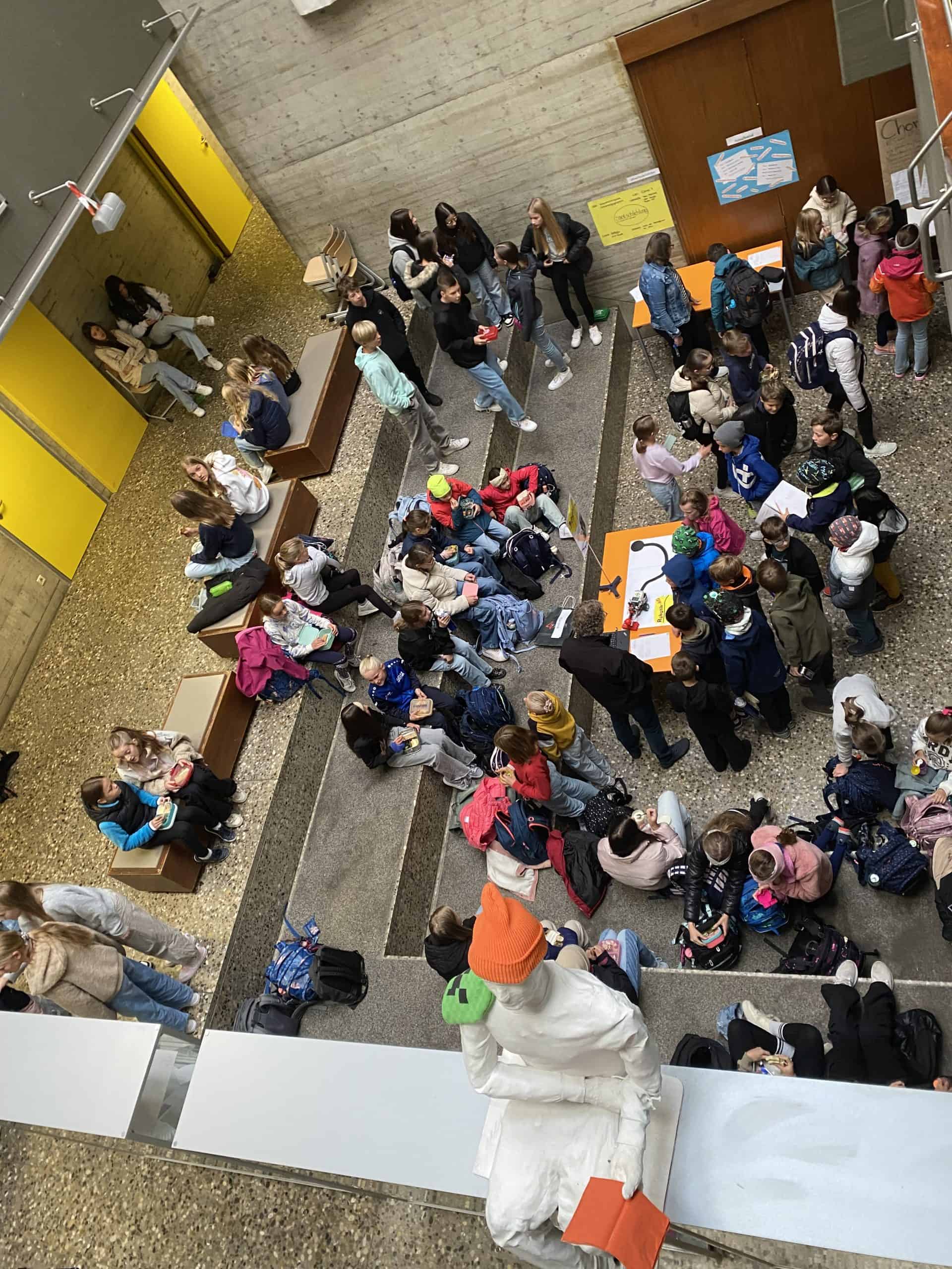 Viele Schüler*innen und Lehrkräfte sprechen an Ständen über die angebotenen AGs